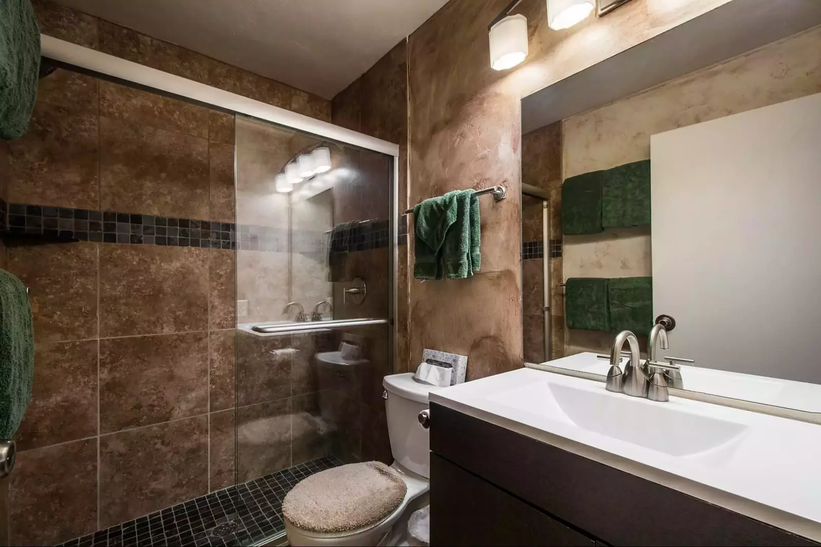 The second bathroom was also recently renovated and features large glass shower with two shower heads, new counter with vanity and modern lighting fix