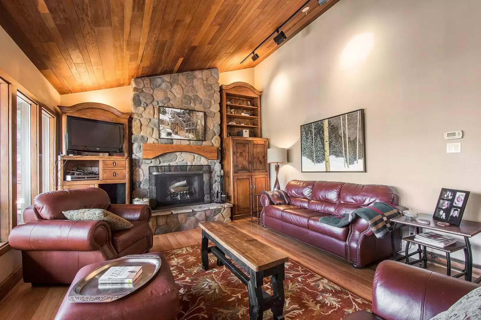 Hand-pieced wood celing and soft spot lighting showcase the living room area with fireplace and 42” HDTV.