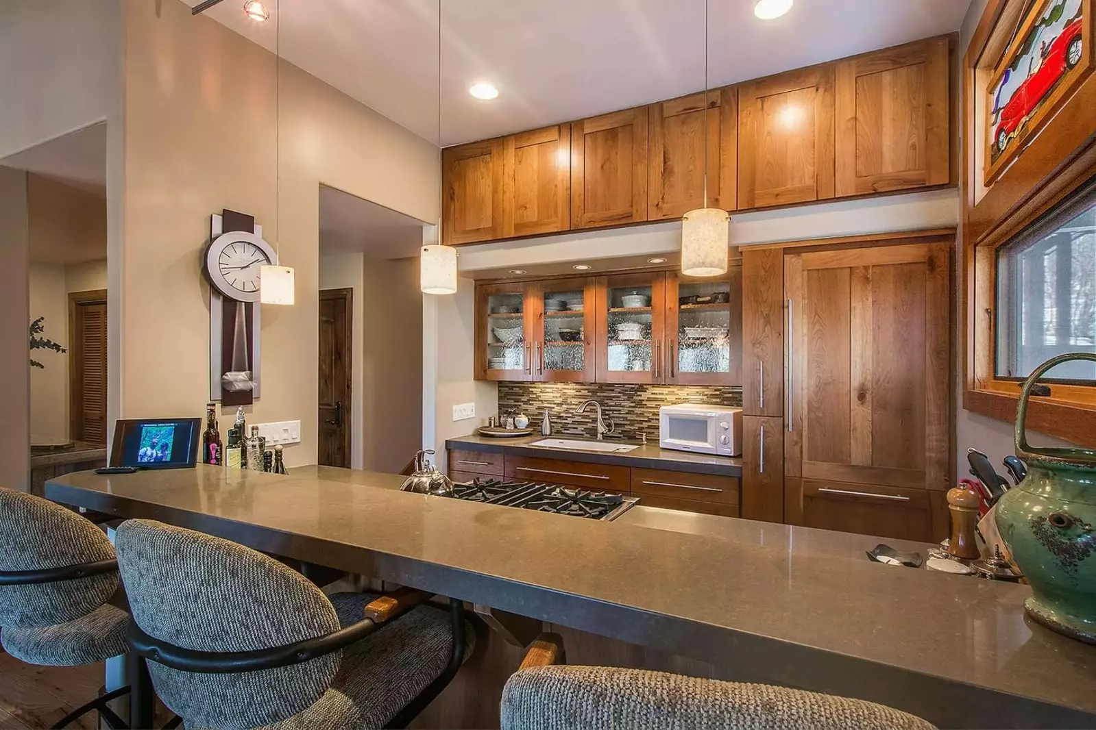 Perfect placed lighting illuminate the beautiful wooden cabinetry and kitchen counters.
