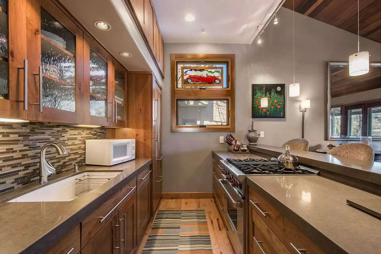 Fully equiped galley kitchen with high-end stove and oven, breakfast bar and comfy chairs.