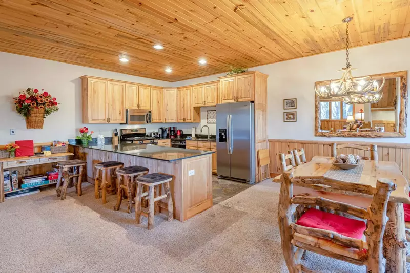 The formal dining room is decorated with an antler chandelier, custom log furniture and hardwood dining room table with plenty of comfortable seating.