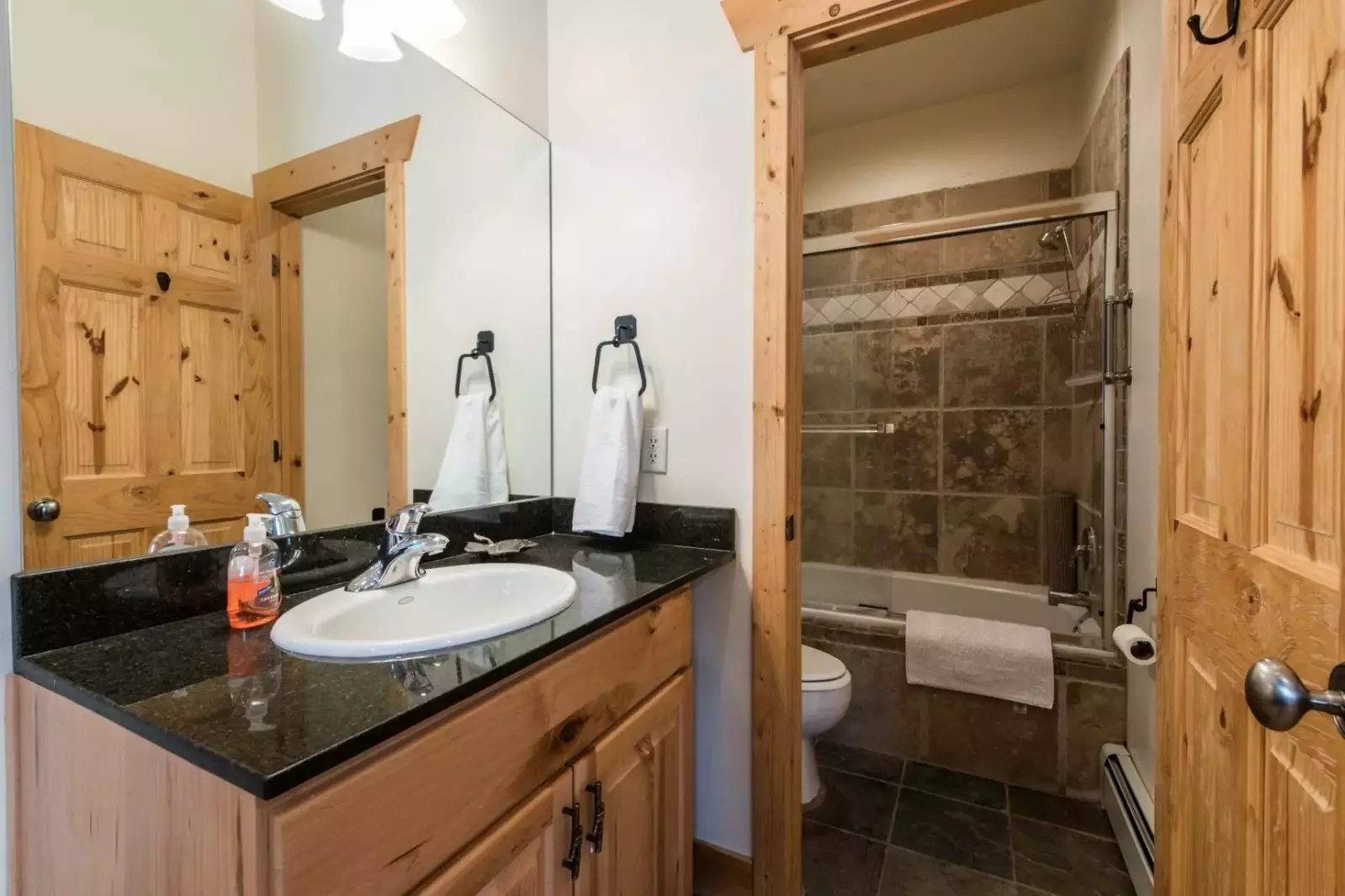 The master bathroom features dark granite counters, stainless steel fixtures, Kohler sink and a fully enclosed soaker tub and shower.