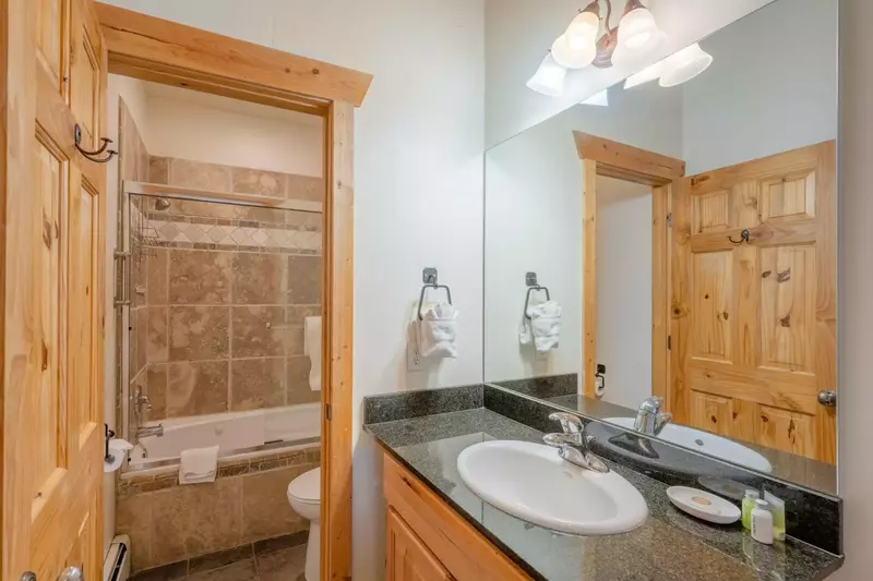 The guest bathroom is equipped with granite counters, stainless steel fixtures, Kohler sink and a fully enclosed tub and shower.