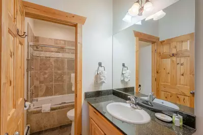 The guest bathroom is equipped with granite counters, stainless steel fixtures, Kohler sink and a fully enclosed tub and shower.