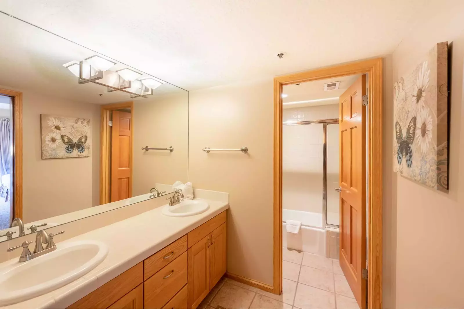 Guest bathroom with two vanities and privacy door to shower & bath