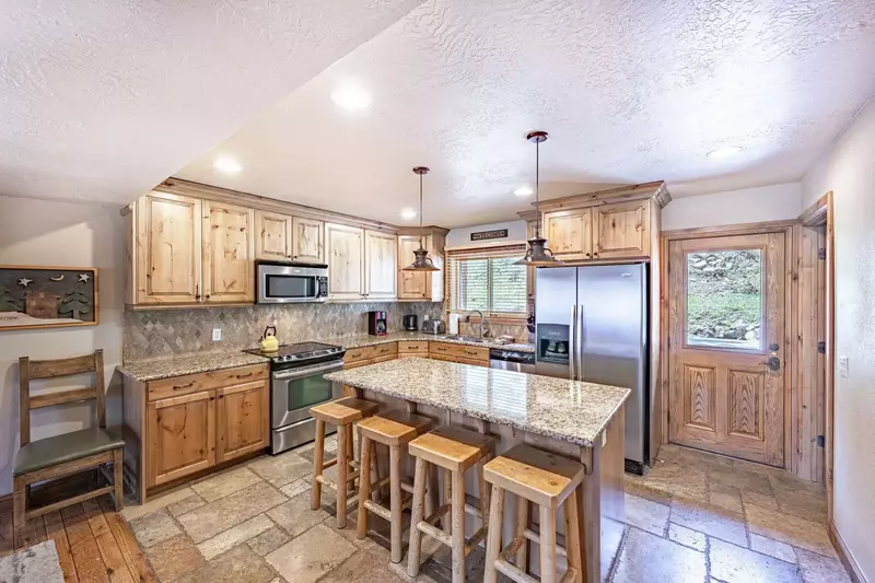 The kitchen is beautifully finished with granite countertops, hardwood cabinetry and a large kitchen island, which can second as a breakfast bar.