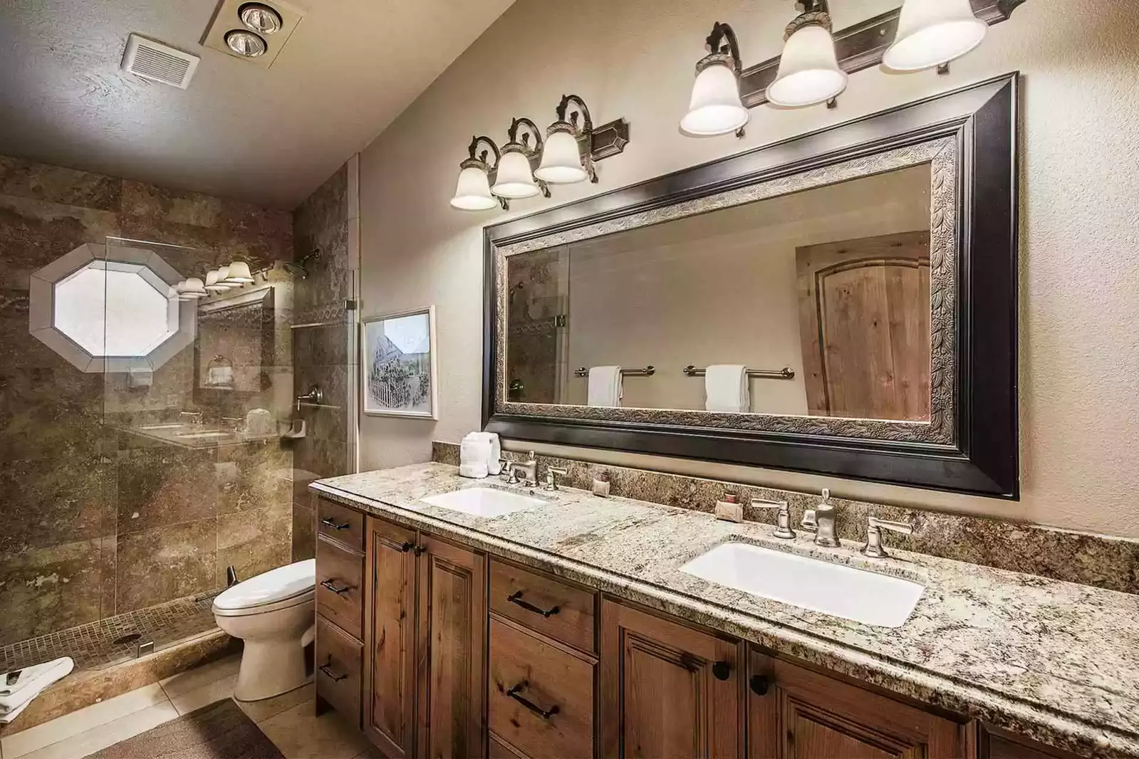 The master bathroom (2) was fully renovated and has a granite countertop with a his and hers vanity, a walk-in shower and stainless steel finishes.