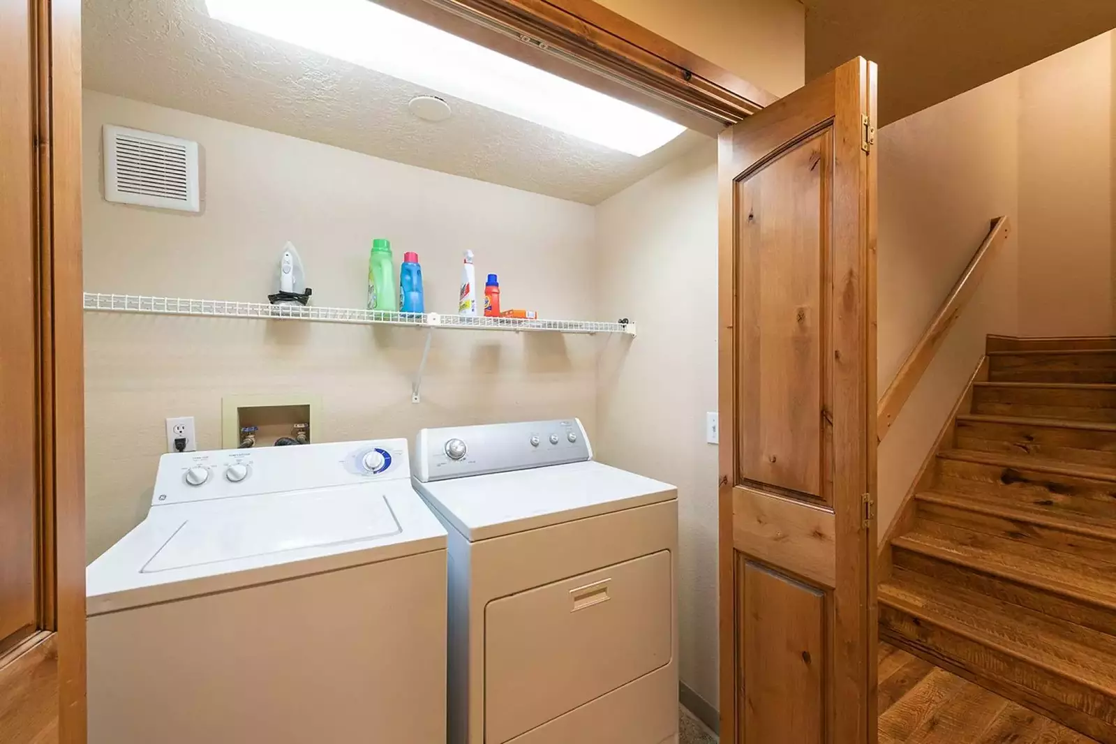 Full size washer and dryer enclosed in bifold doors.