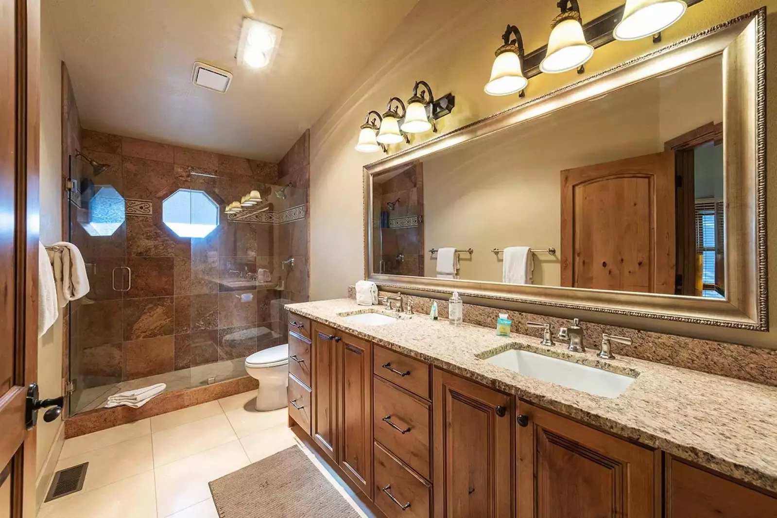The master bathroom (2) with his and hers vanity and walk-in shower.