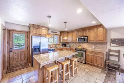Renovated chef’s kitchen with granite counters & breakfast bar