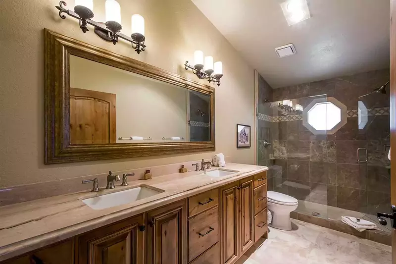 BEDROOM #1 bathroom was fully renovated and has a granite countertop with a his and hers vanity, a walk-in shower and stainless steel finishes.