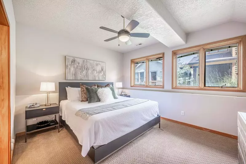 Experience comfort and luxury in this welcoming primary suite. With a top-tier king-size bed, expansive windows, a refreshing ceiling fan, and a priva