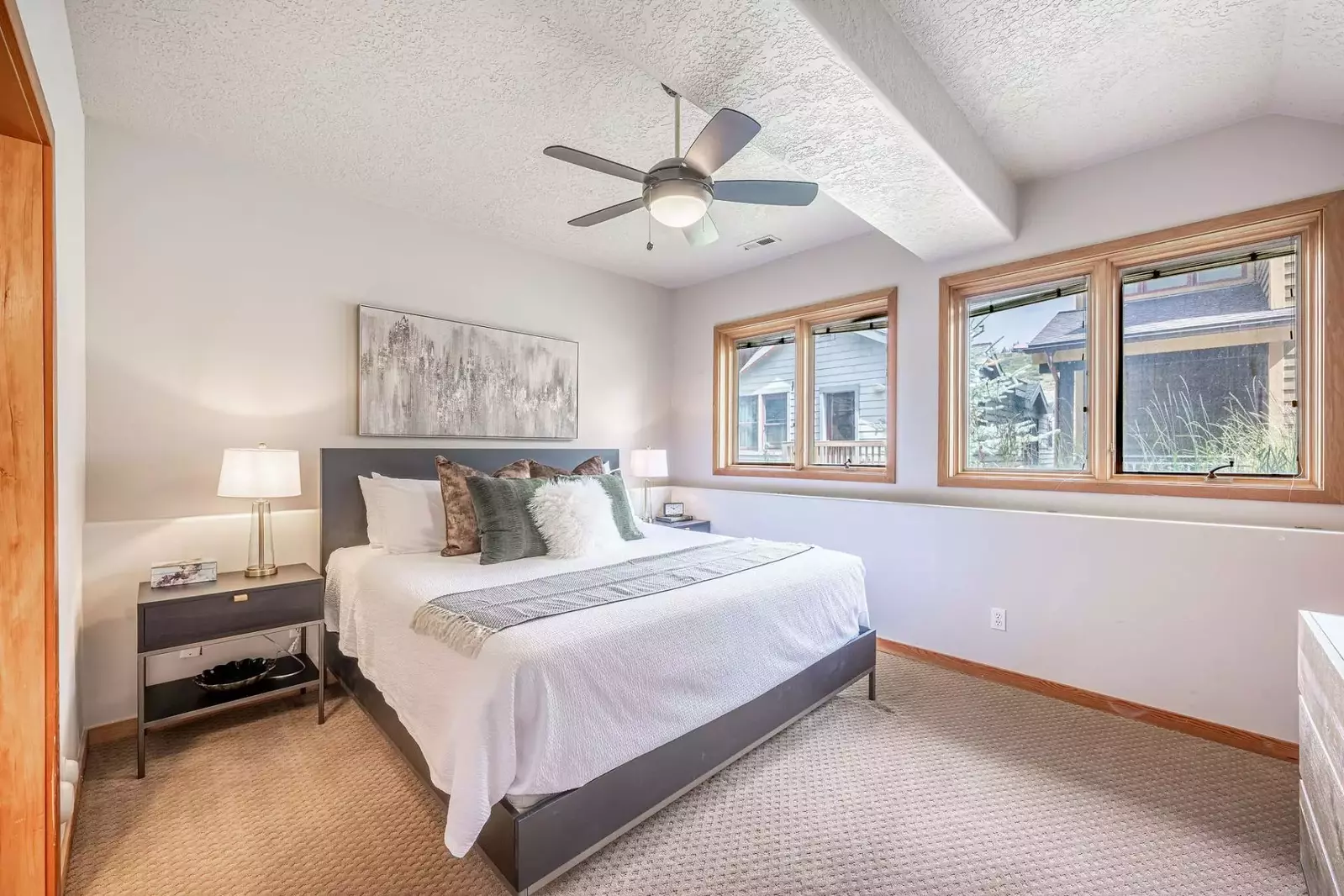 Experience comfort and luxury in this welcoming primary suite. With a top-tier king-size bed, expansive windows, a refreshing ceiling fan, and a priva