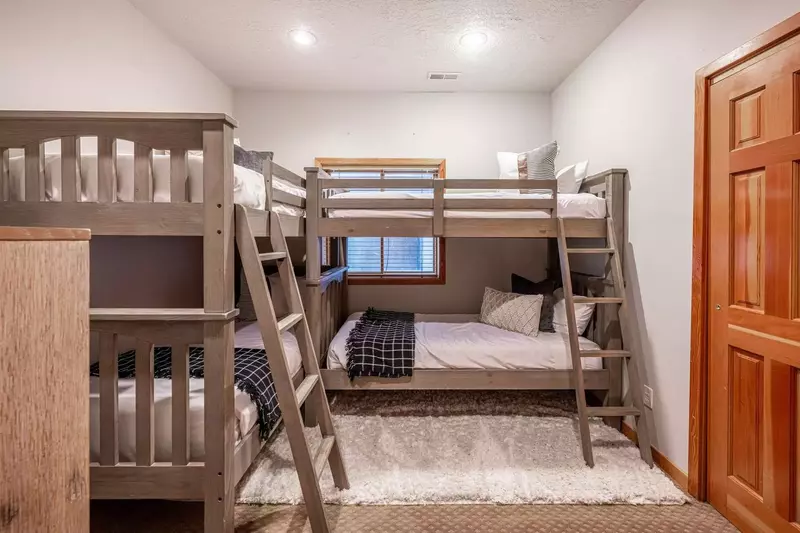 This home offers a unique feature with two bunk rooms, including a guest suite with two sets of twin bunk beds that can accommodate up to four guests.