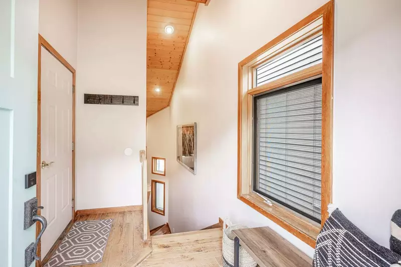 This entryway offers convenient hooks for hanging coats and bags, along with a comfortable bench for shoe removal. Perfect for a cozy and organized st