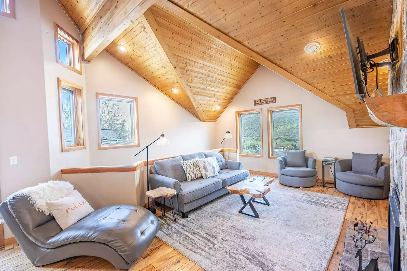 Designer Furniture, Leather Chaise Lounge, Comfortable Sofa, Vaulted Ceiling, Gas Fireplace, Oversized Windows (stairs behind sofa lead down to bedroo