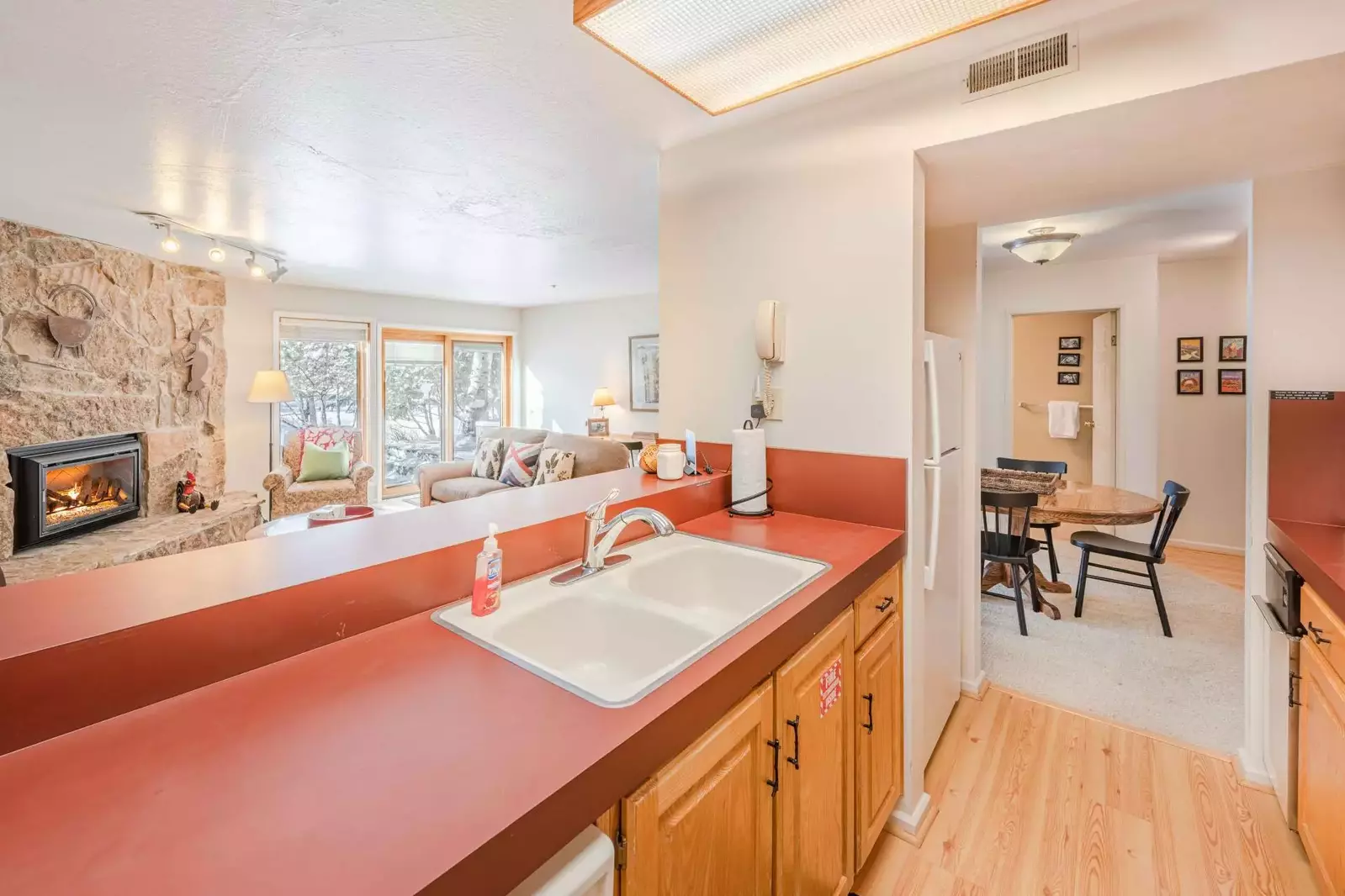 The open concept kitchen overlooks the family room and features a spacious breakfast bar, hardwood flooring and hardwood cabinetry.