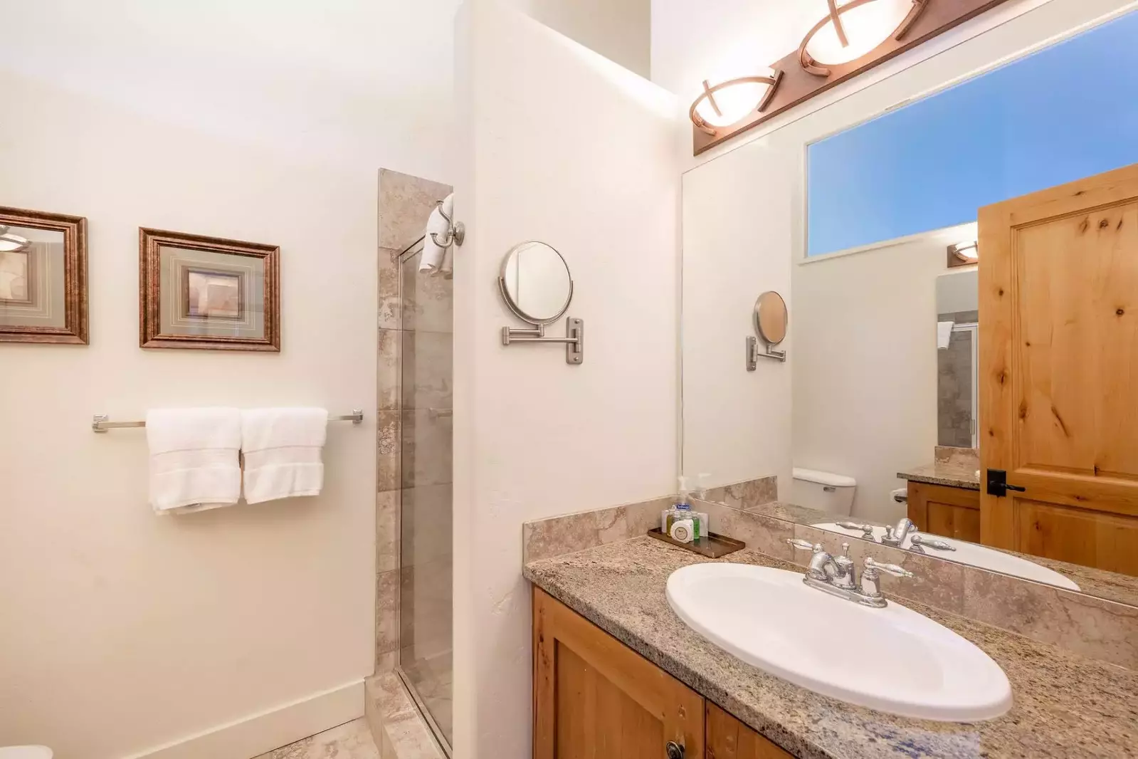 The primary suite en suite has an oversized, walk in glass shower and two separate vanity areas