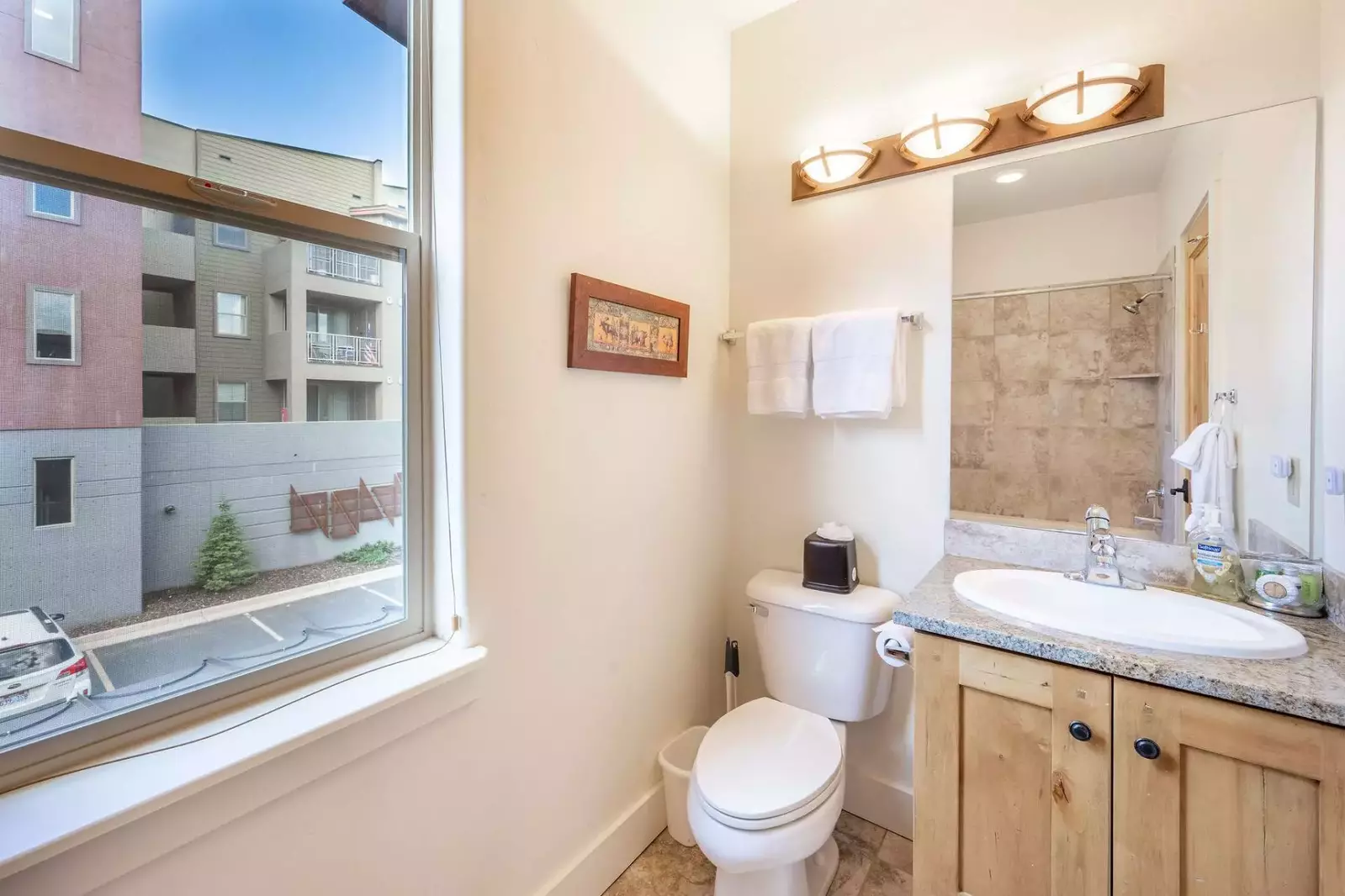 Located in the guest suite is the full guest bathroom - complete with privacy shades, granite vanity, stone tiled shower and bath
