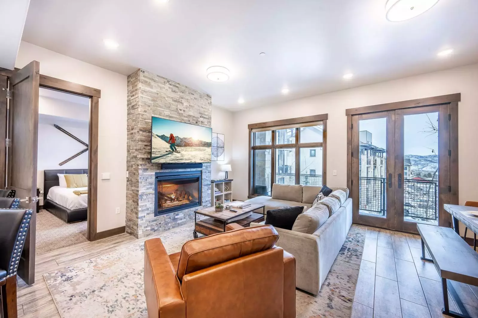 The living room features a gas fireplace, luxury furniture, and a large smart tv.