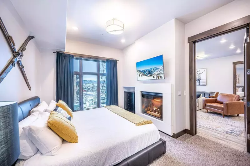 The primary bedroom features a luxurious king sized bed, a private gas fireplace, and an HDTV.