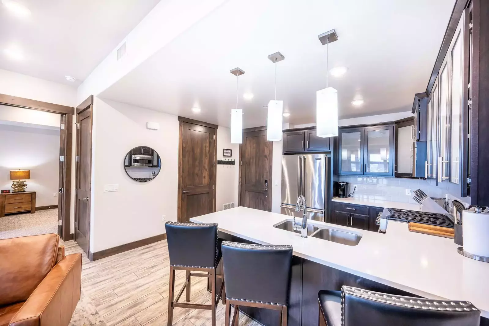 This warm kitchen offers upgraded appliances, quartz countertops, and a breakfast bar with seating for 3 guests.