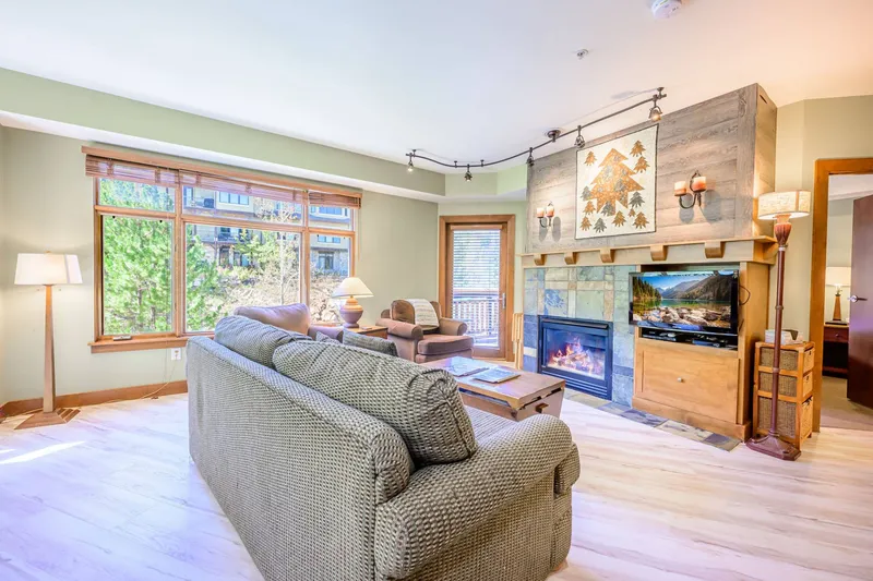 Cozy up next to the stone fireplace in our open-concept, Park City living room with new hardwood flooring and updated furniture.