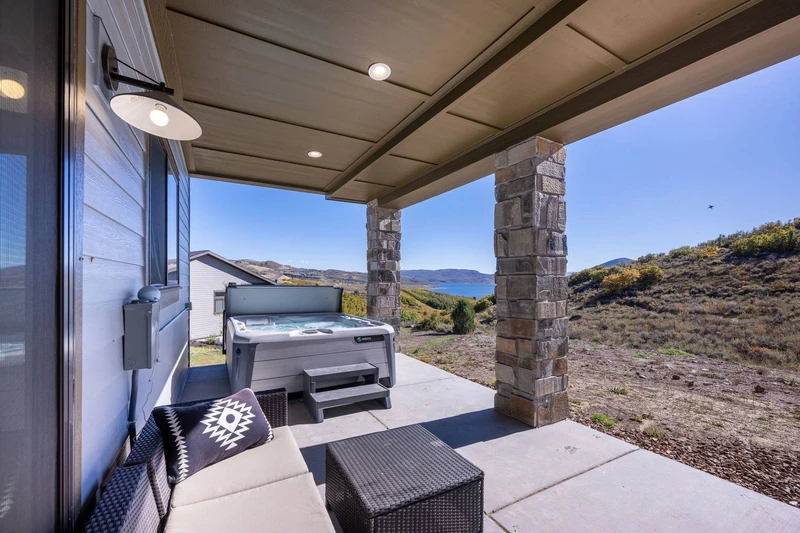 The back patio of the home features stunning views of the Jordanelle Reservoir in the large hot tub.