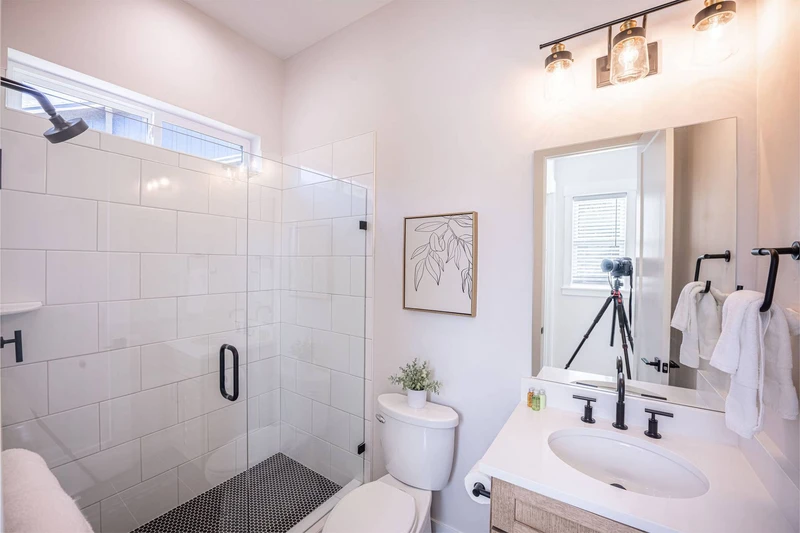 The bathroom with upgraded tile, an oversized walk in shower, and ample space is on the upper level of the home and is shared with 2 bedrooms