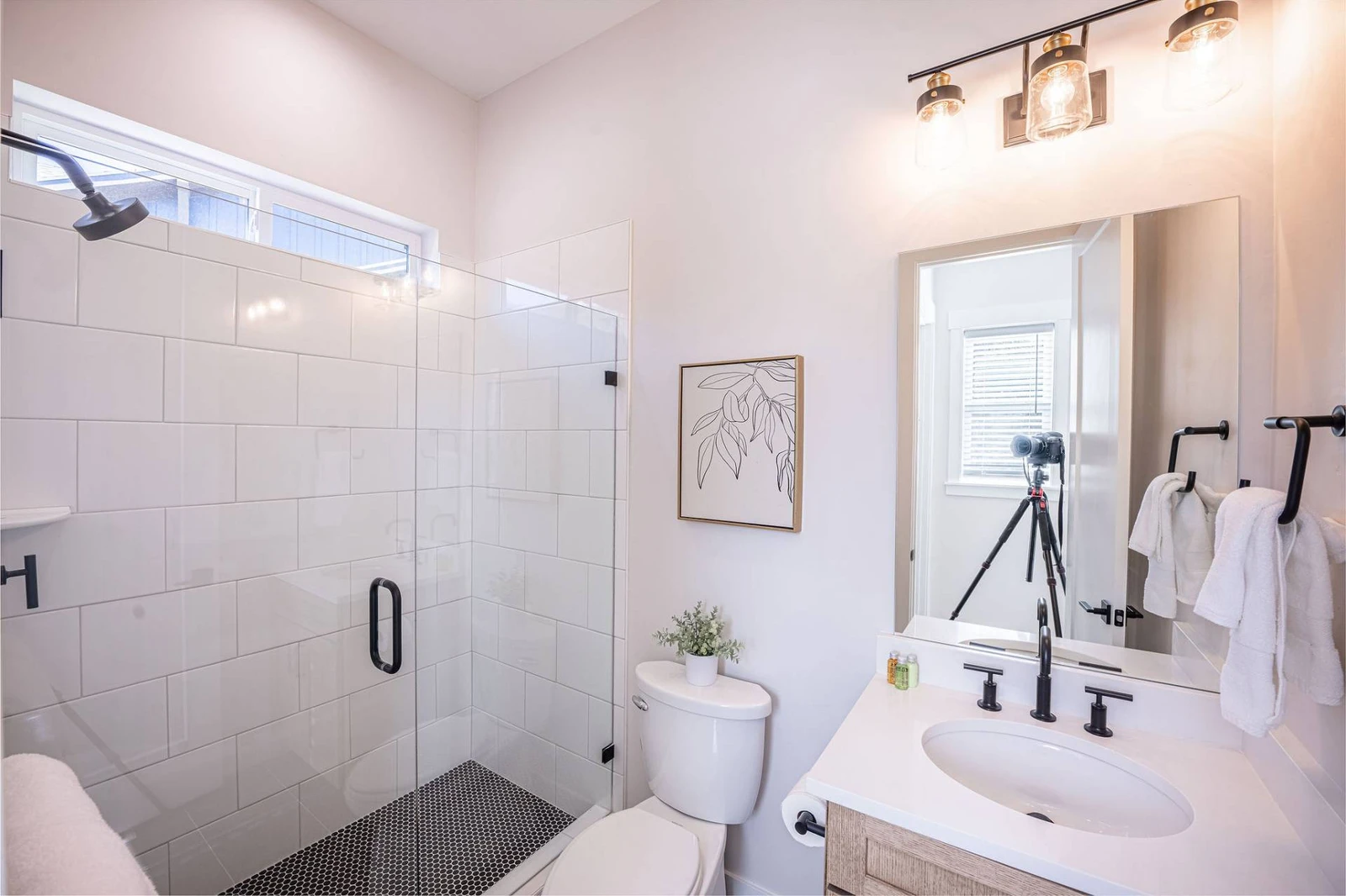 The bathroom with upgraded tile, an oversized walk in shower, and ample space is on the upper level of the home and is shared with 2 bedrooms