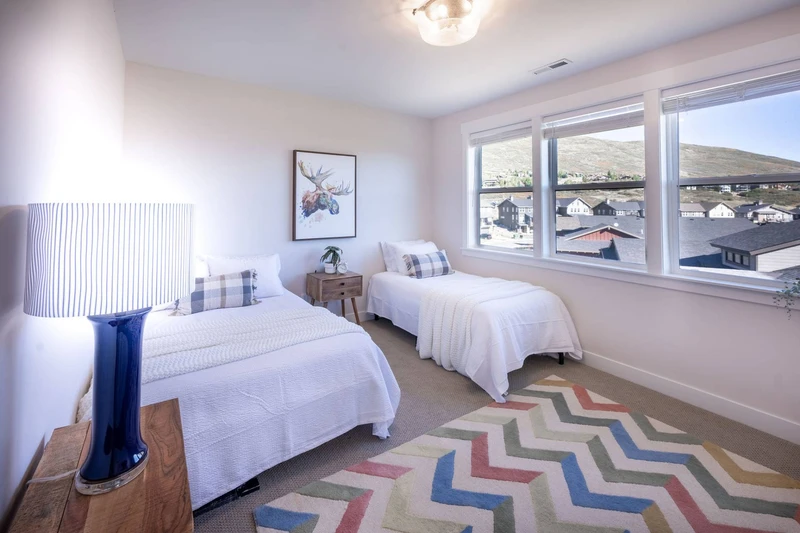 The spacious guest suite on the upper floor of the home features a full sized bed and a twin sized bed