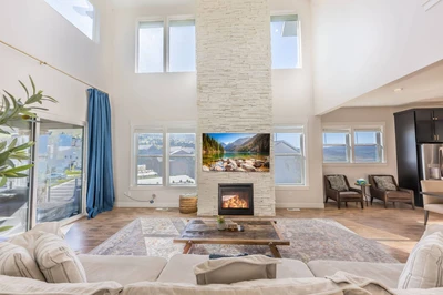 Great Room — two-story stacked stone fireplace, vaulted ceiling, clerestory windows | The Gathering House at Jordanelle