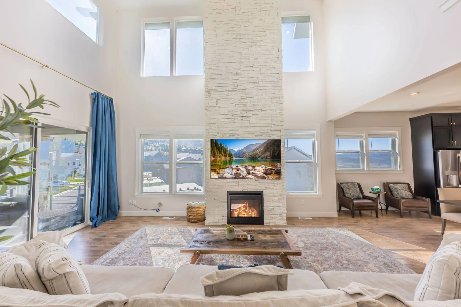 Great Room — two-story stacked stone fireplace, vaulted ceiling, clerestory windows | The Gathering House at Jordanelle