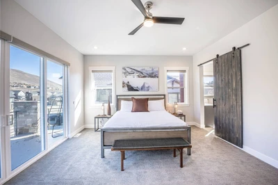The primary bedroom offers a king sized bed, access to the private balcony, and a luxurious oversized primary en suite bathroom