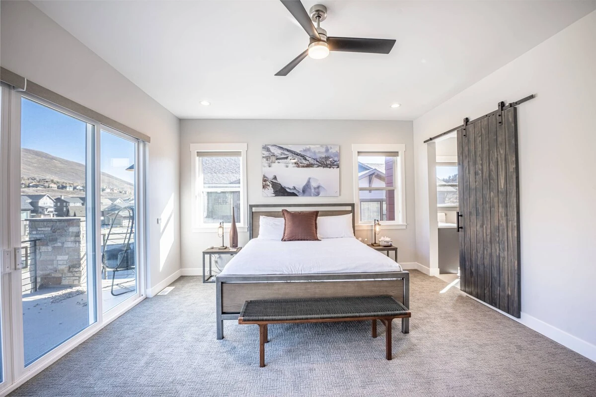 The primary bedroom offers a king sized bed, access to the private balcony, and a luxurious oversized primary en suite bathroom