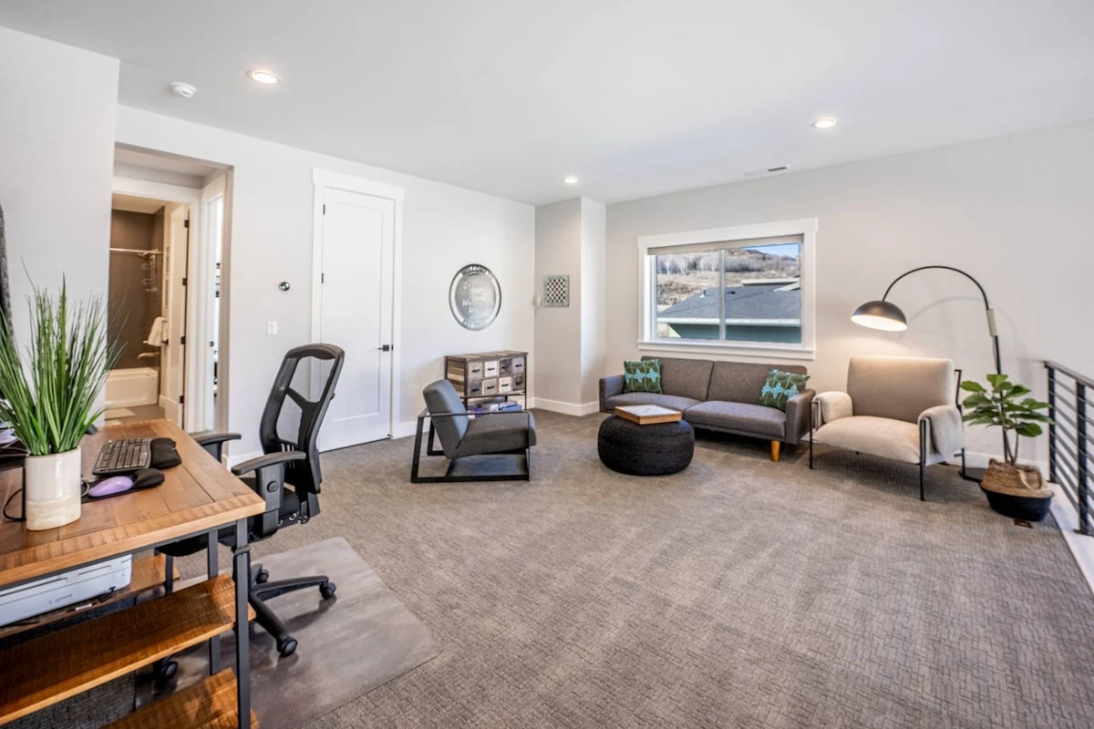 The upstairs loft features a futon sleeper sofa and a comfortable work from home space with a large desk and comfortable chair