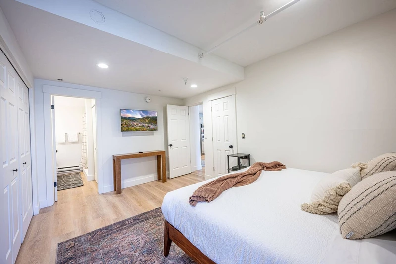 Primary Suite with king bed made with clean, triple-sheeted bedding. HDTV with streaming, closet for storage, bathroom access.