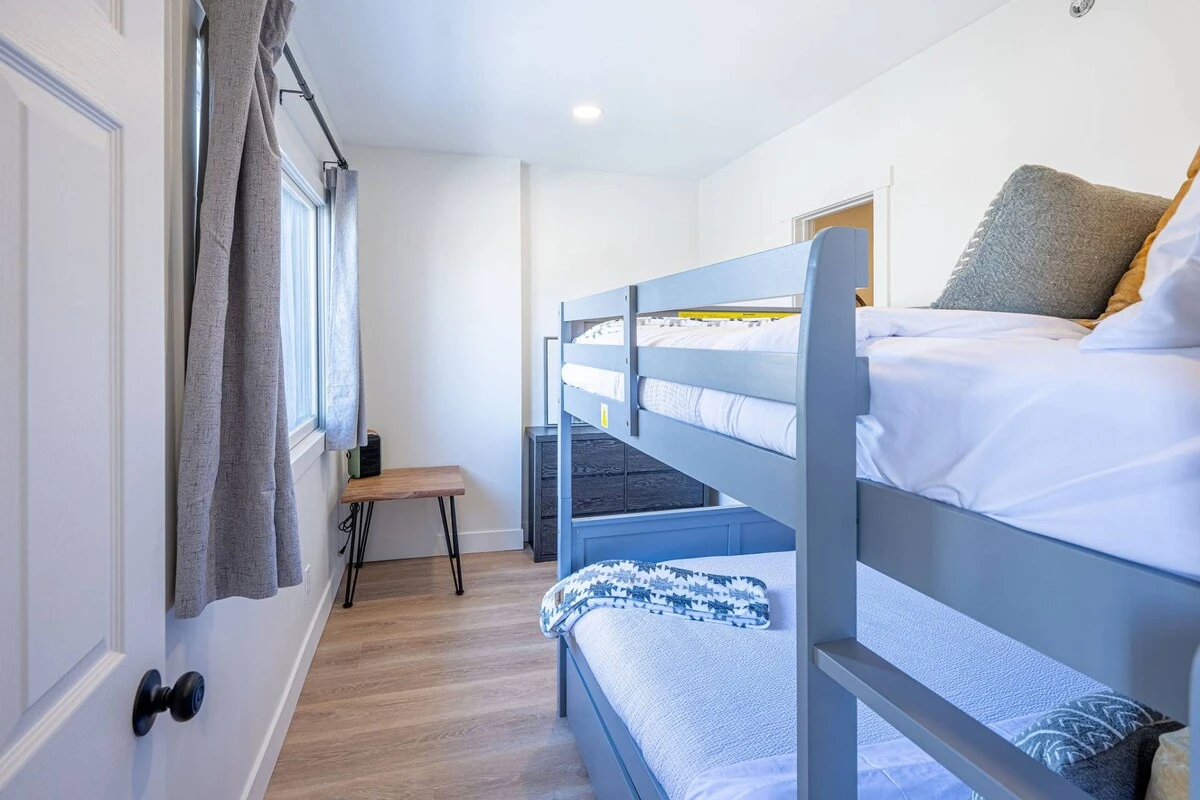 Guest Suite with twin bunk beds, dresser, and access to a full bathroom. Perfect for Families