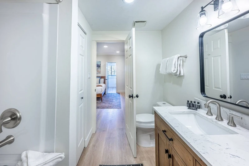 Primary En Suite Bathroom with dual vanitiy, fresh towels and standard amenities.