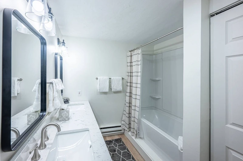 Primary En Suite Bathroom with dual vanitiy, fresh towels and standard amenities.