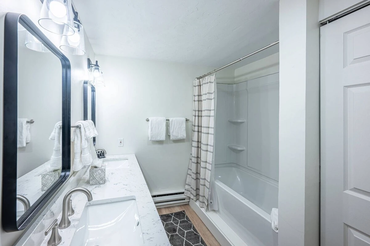Primary En Suite Bathroom with dual vanitiy, fresh towels and standard amenities.