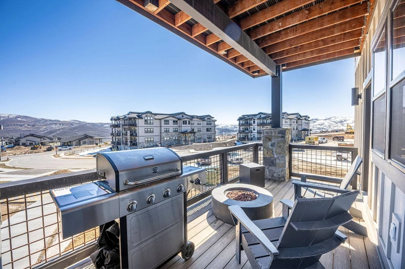The private balcony features a gas bbq grill and fire pit with stunning mountain views