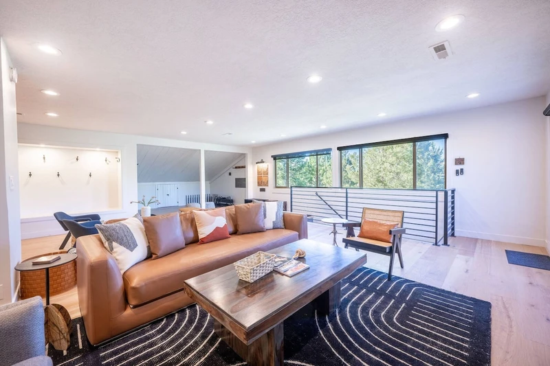 Living room at the Prospector Penthouse in Park City, Utah, with a sofa sleeper, fireplace, HDTV, sound system and hardwood floors. New designer furnishings make this ski condo perfect for après-ski evenings.
