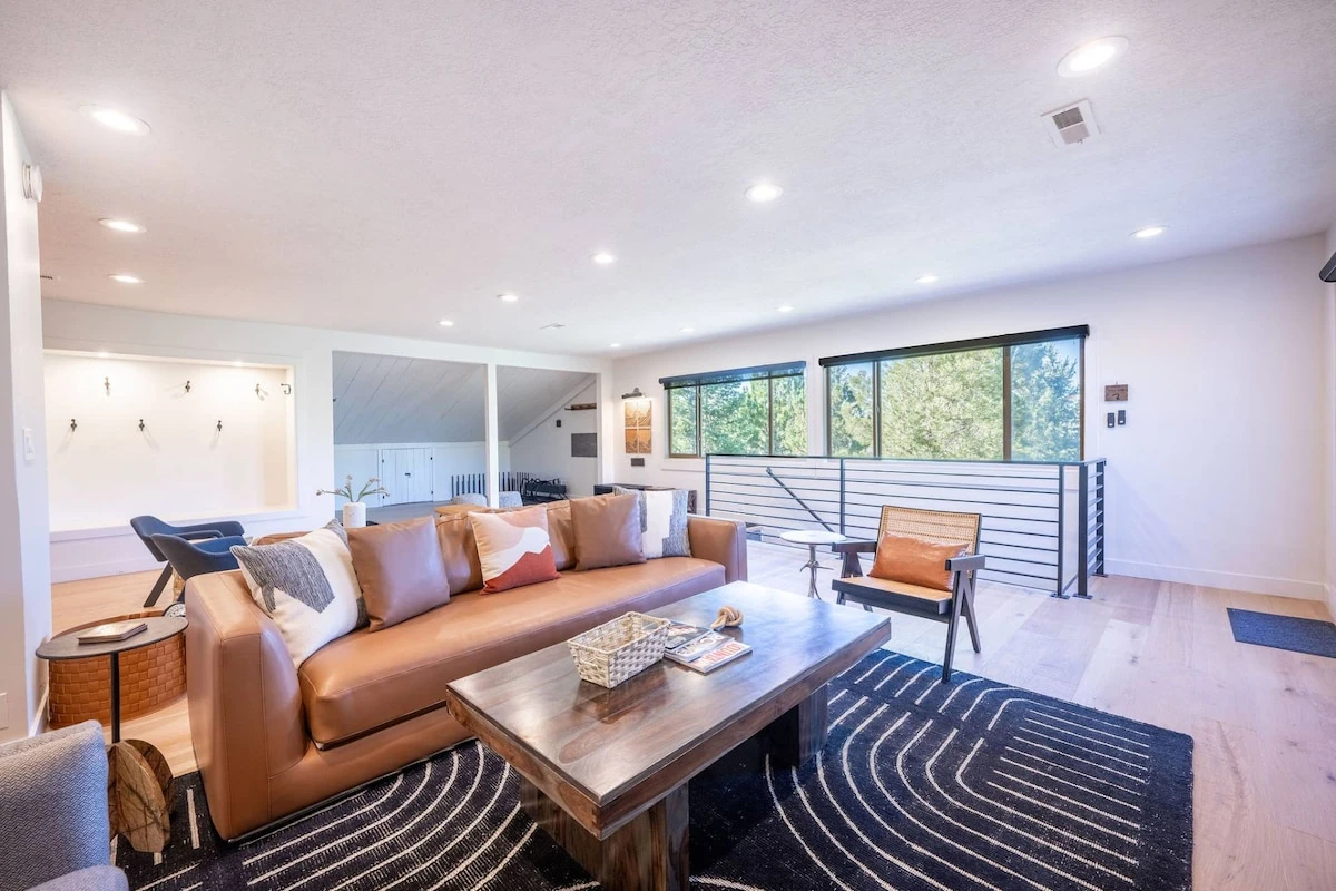 Living room at the Prospector Penthouse in Park City, Utah, with a sofa sleeper, fireplace, HDTV, sound system and hardwood floors. New designer furnishings make this ski condo perfect for après-ski evenings.
