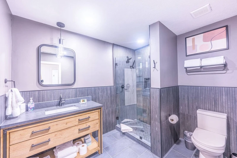This Park City vacation rental has 2 full bathrooms. This is the Guest bathroom that features a modern walk in glass shower, large vanity and toilet. 