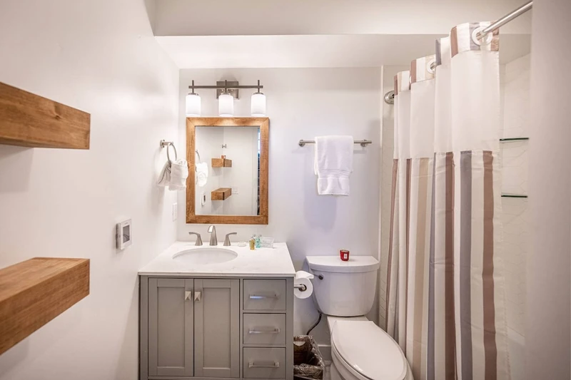 Located just outside the guest room is a bathroom. The middle level bathroom was updated in 2022 and features a new oversized vanity