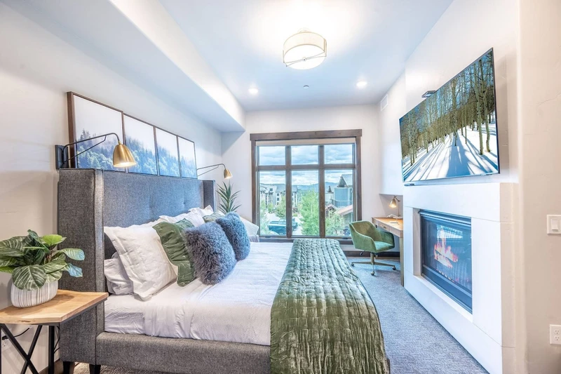 Primary suite features a large gas fireplace and mountain views from the floor to ceiling windows
