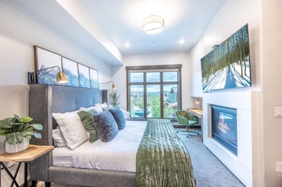Primary suite features a large gas fireplace and mountain views from the floor to ceiling windows