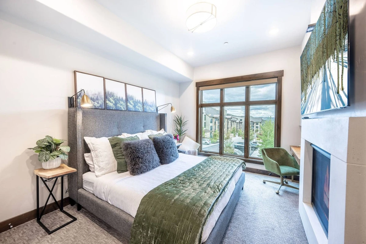 Warm and inviting primary suite that featuring a king sized bed, gas fireplace, private work desk, and large HDTV