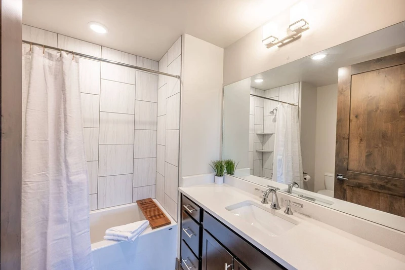 Modern full sized bathroom in the guest suite with an extra deep bathtub and large vanity
